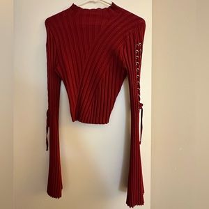 Medium, burgundy, long sleeve shirt with braiding detail along the arm.